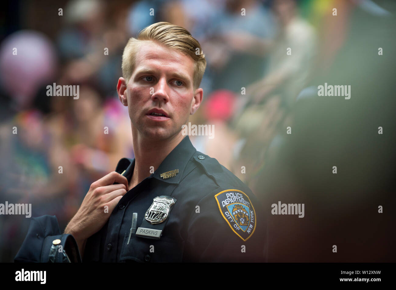 NEW YORK CITY - JUNE 25, 2017: A handsome young NYPD Police officer provides security on the sidelines of the annual Pride Parade in the Village. Stock Photo
