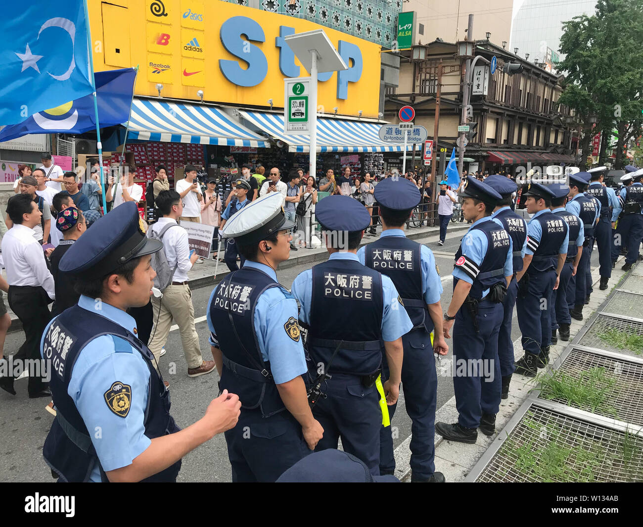 Osaka, Japan. 29th June, 2019. A group of police officers direct the  traffic of a protest in Osaka Japan where at the same time the Osaka G20  summit was taking place. Osaka