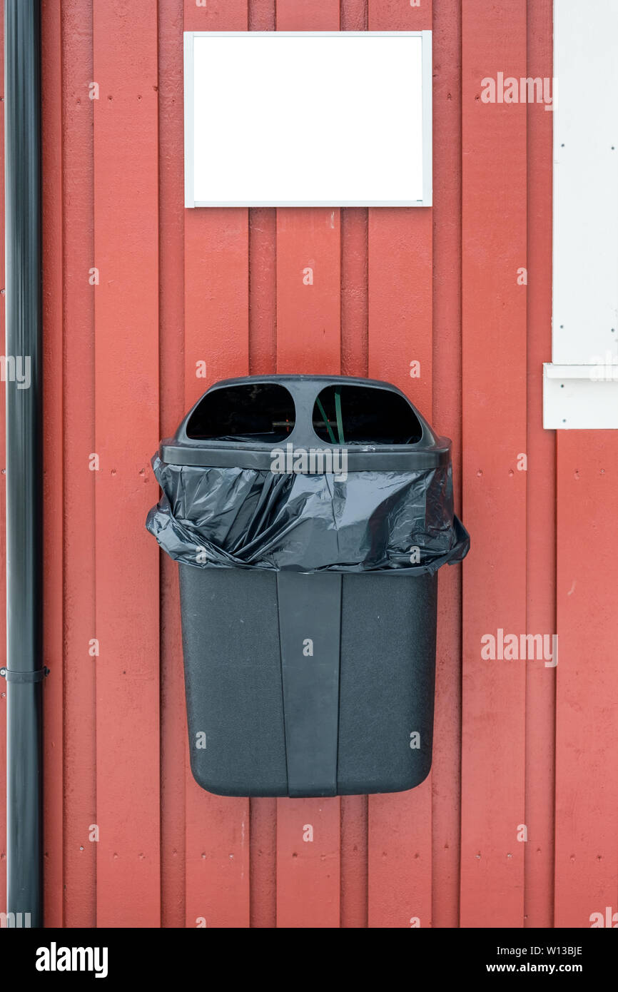 https://c8.alamy.com/comp/W13BJE/plastic-garbage-with-bag-hanging-on-wooden-wall-with-blank-signboard-W13BJE.jpg
