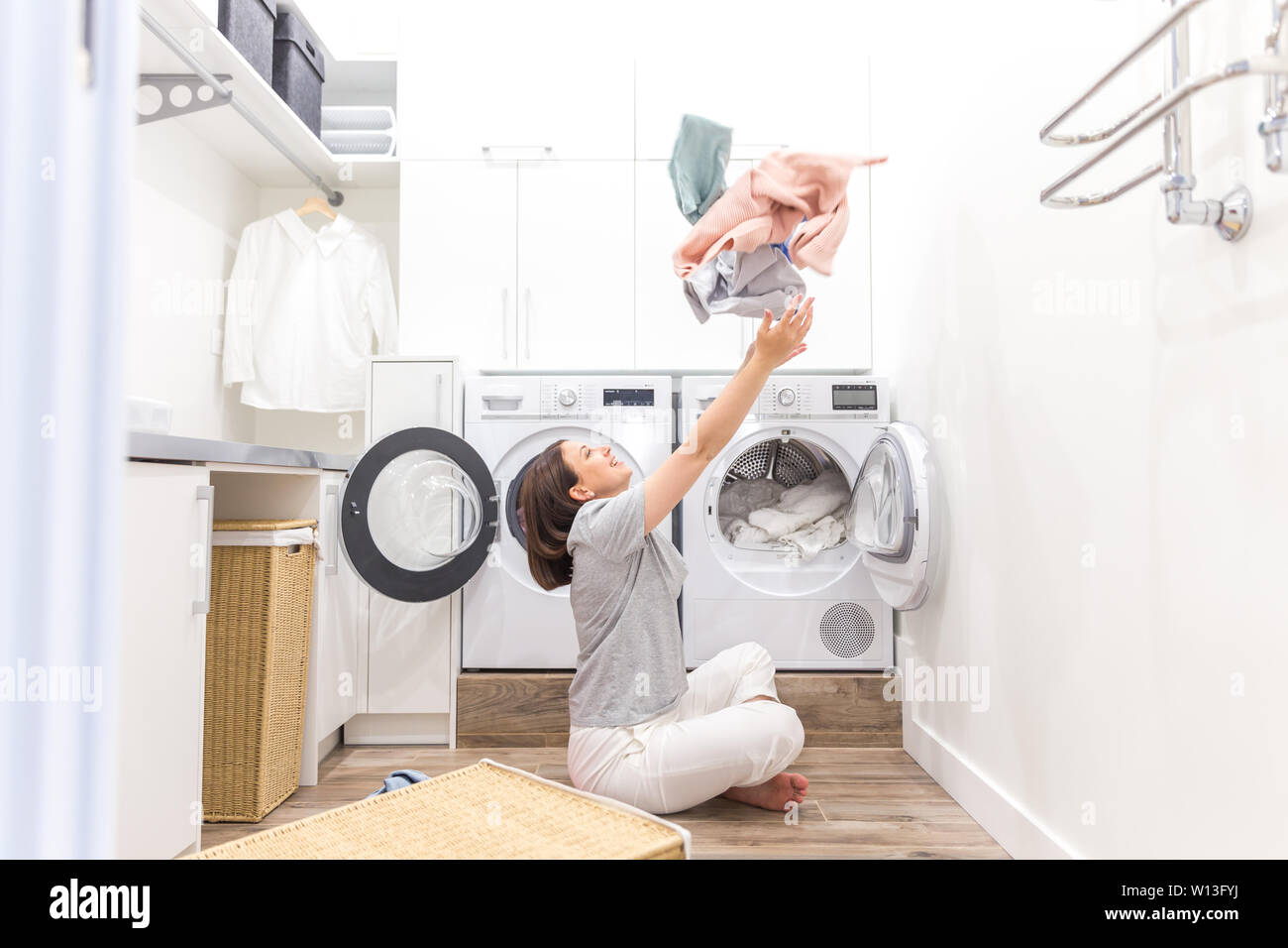 Happy family mother housewife in laundry room with washing machine