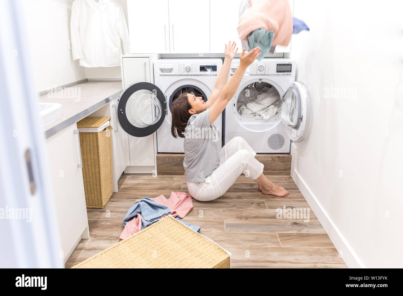 Happy family mother housewife in laundry room with washing machine