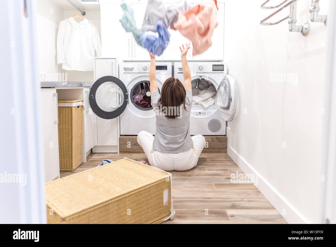Happy family mother housewife in laundry room with washing machine