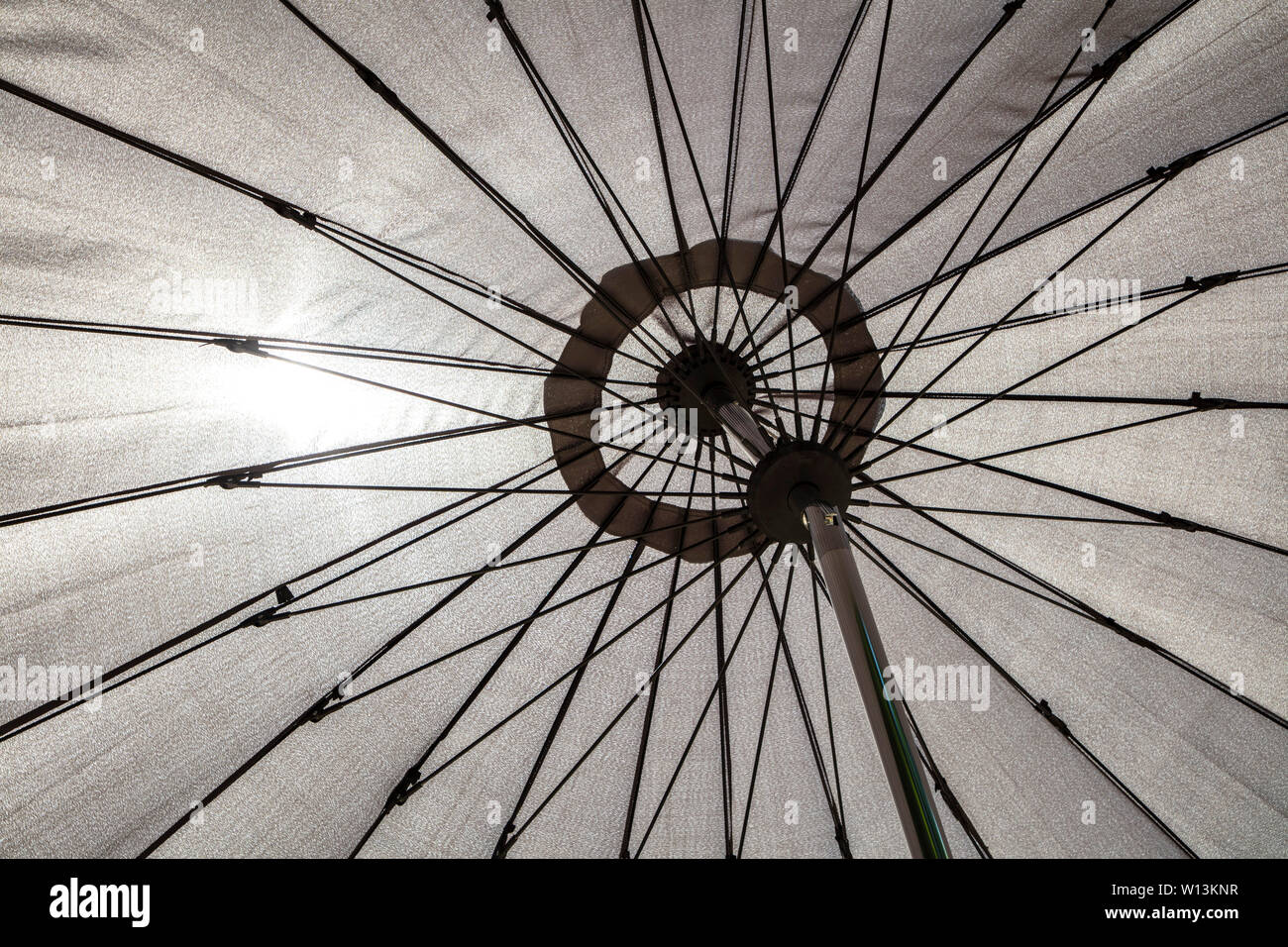 Abstract view of the sun shining through a garden table parasol in