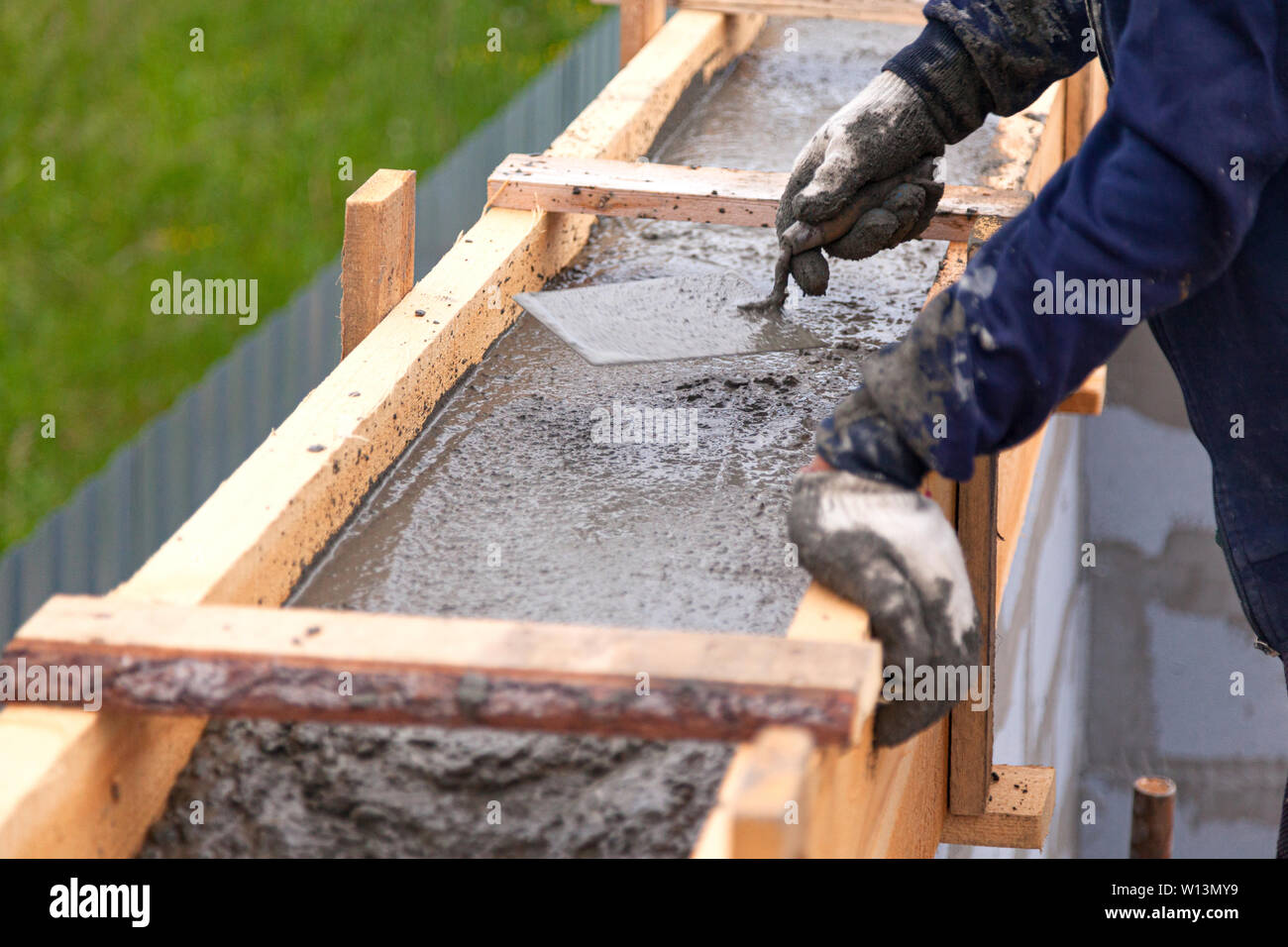Worker levels concrete in formwork using a trowel Stock Photo