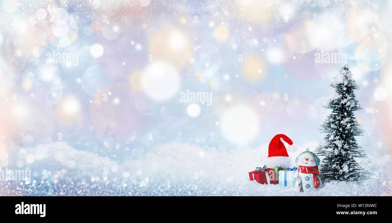 Snowman fir tree and christmas gifts on sleigh on snow, falling snow ...