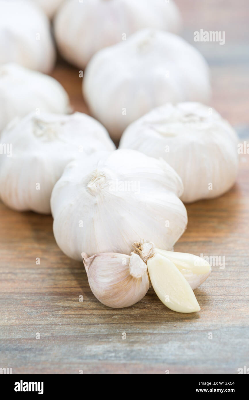 Peeled garlic and full garlic on wooden table Stock Photo - Alamy