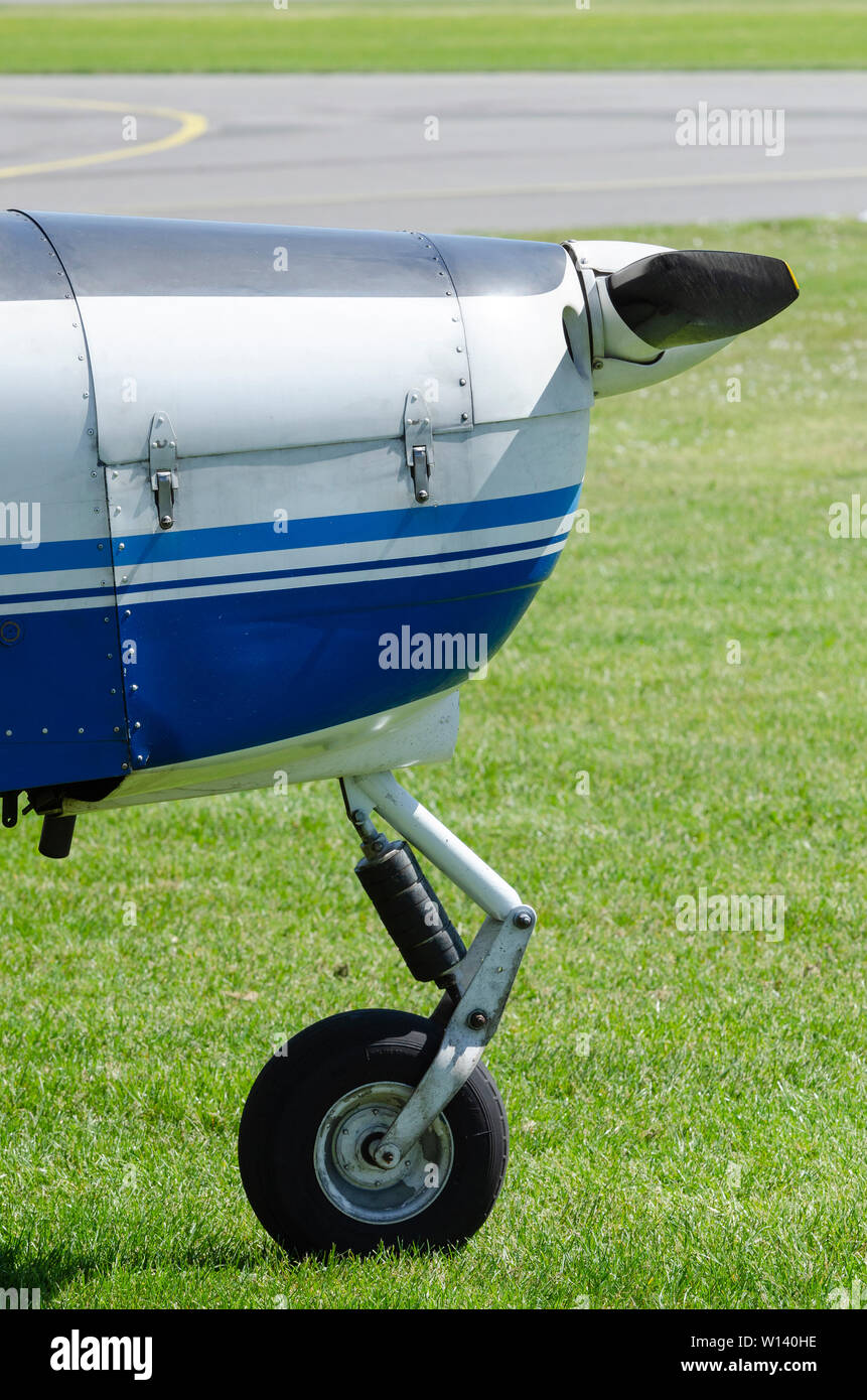 Nose with nose wheel of a single-engine plane on a small sport airfield on the grass Stock Photo