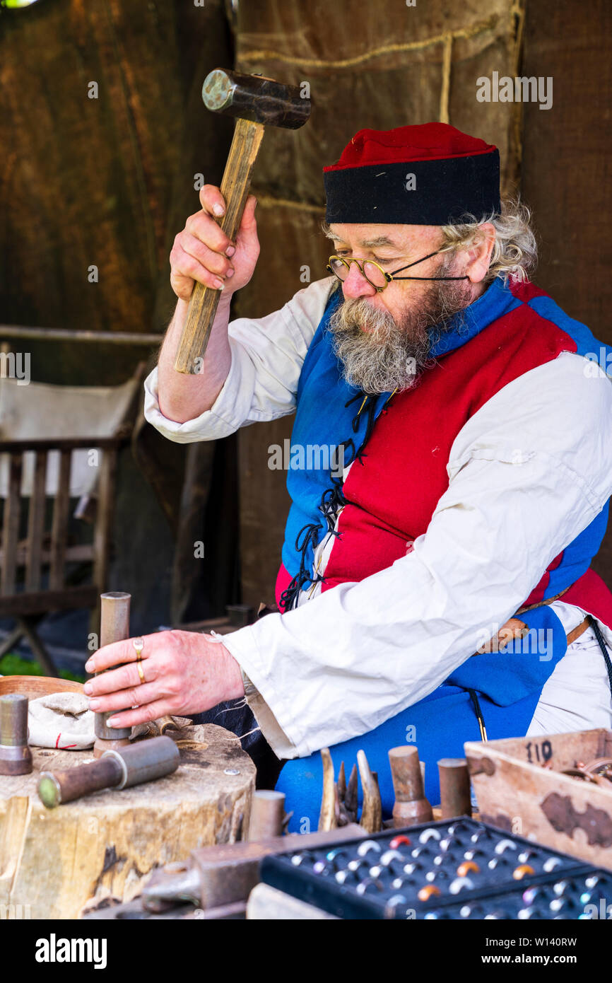 Medieval reenactment event. Senior man metal worker with bushy