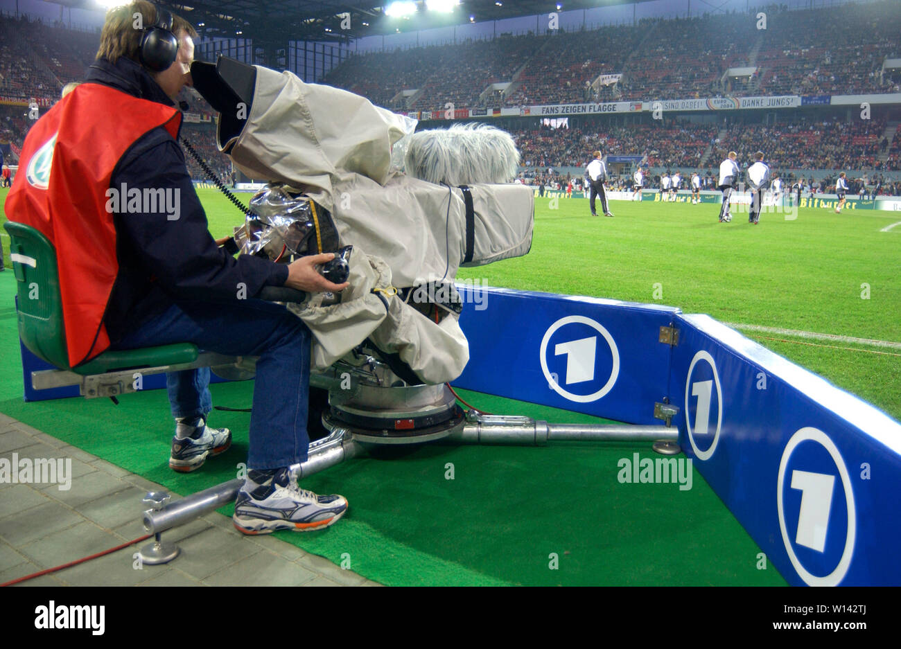 Rhein-Energie-Stadion Cologne Germany, 31.3.2004, Football: International friendly, Germany (white) vs. Belgium (red) 3:0 --- TV cameraman of the German Television channel 'Das ERSTE' (ARD) on the sidelines of the pitch Stock Photo
