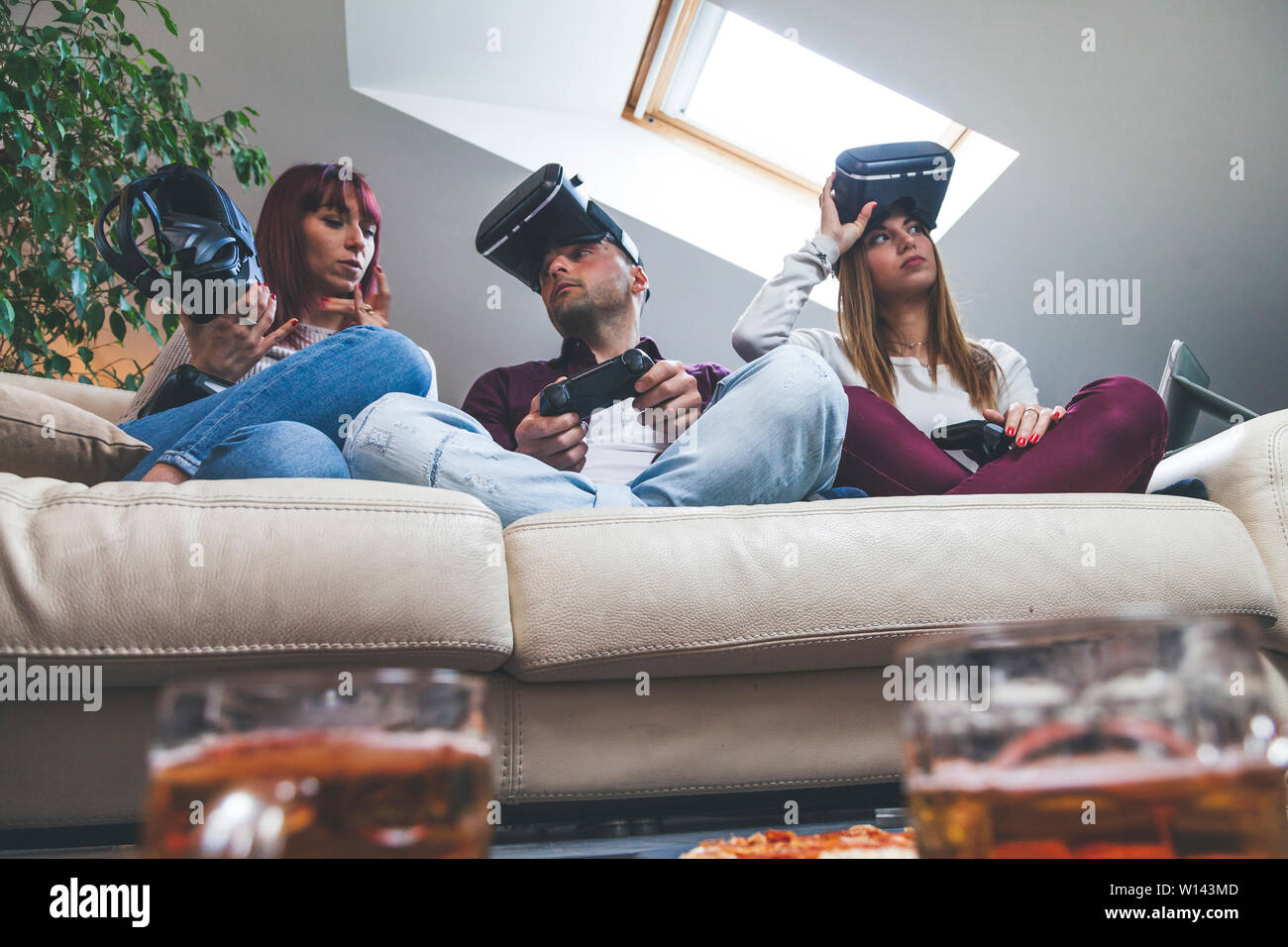 Young happy three friends playing video games virtual reality glasses in  their apartment - concept of cheerful people having fun with new trends  techn Stock Photo - Alamy