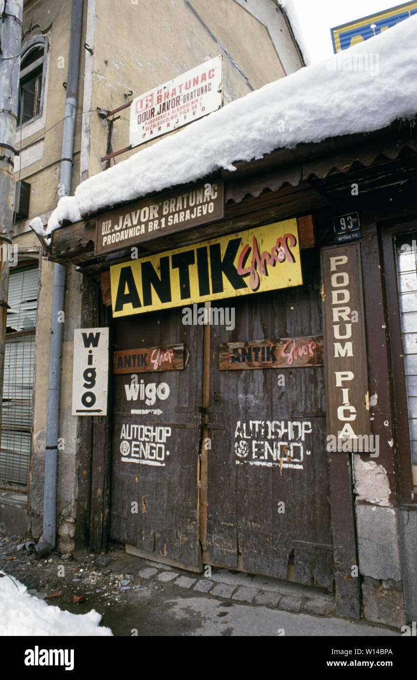 28th March 1993 During the Siege of Sarajevo: a shut-down antiques store at 93 Marsala Tita Street in the Baščaršija area. On a gable wall above it is the typical scar of a direct hit from a mortar or artillery shell. Stock Photo