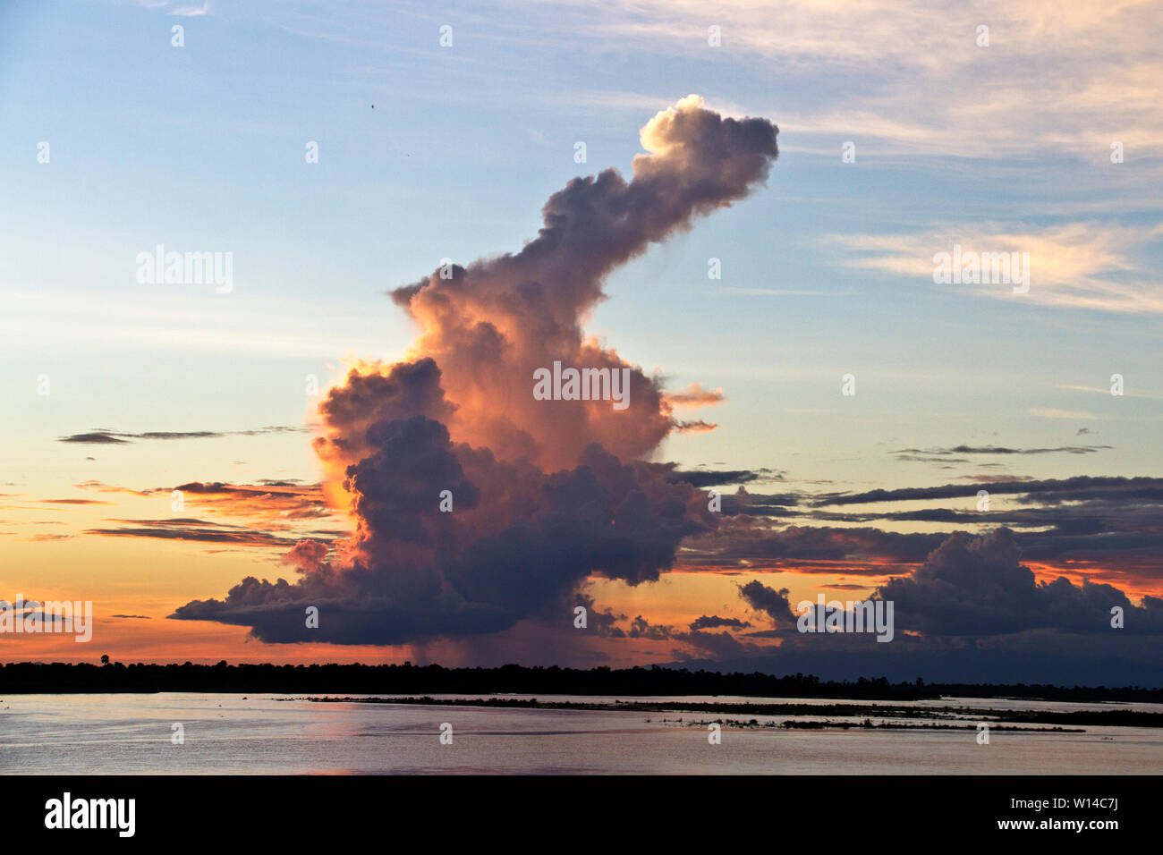 Showers fall from an isolated twering cumulo-nimbus. The convection  currents within these huge columns of violently circulating water vapout  can produ Stock Photo