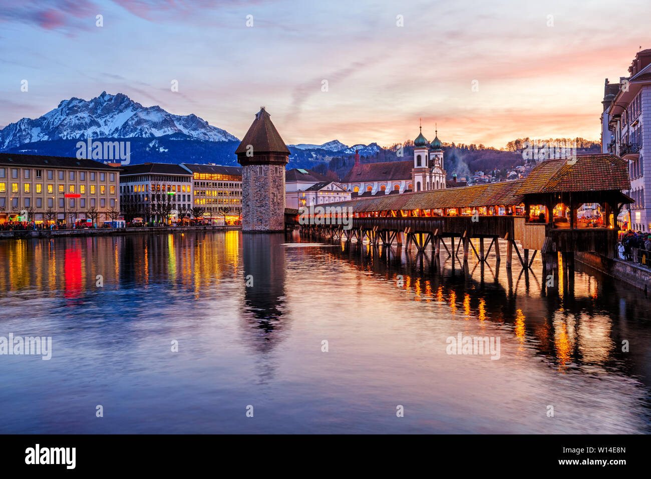 Lucerne, Switzerland, the wooden Chapel bridge in historical Old town and Mount Pilatus reflecting in Reuss river on dramatical sunset Stock Photo