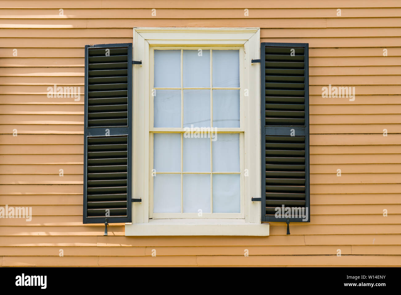 Detail of historic double hung window with black shutters on a historic home in New England Stock Photo