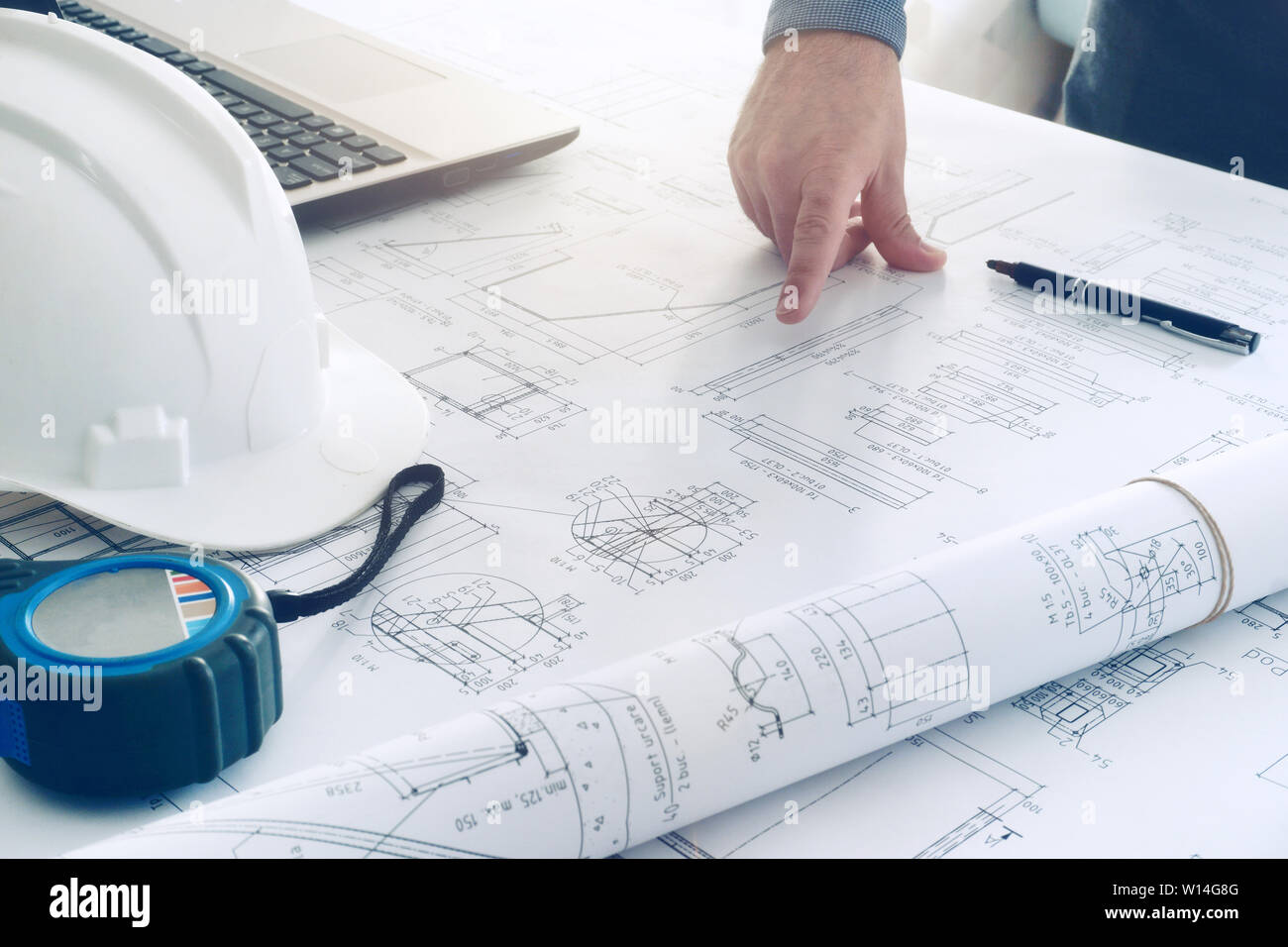 construction blueprints engineering man hard white helmet work table Stock Photo