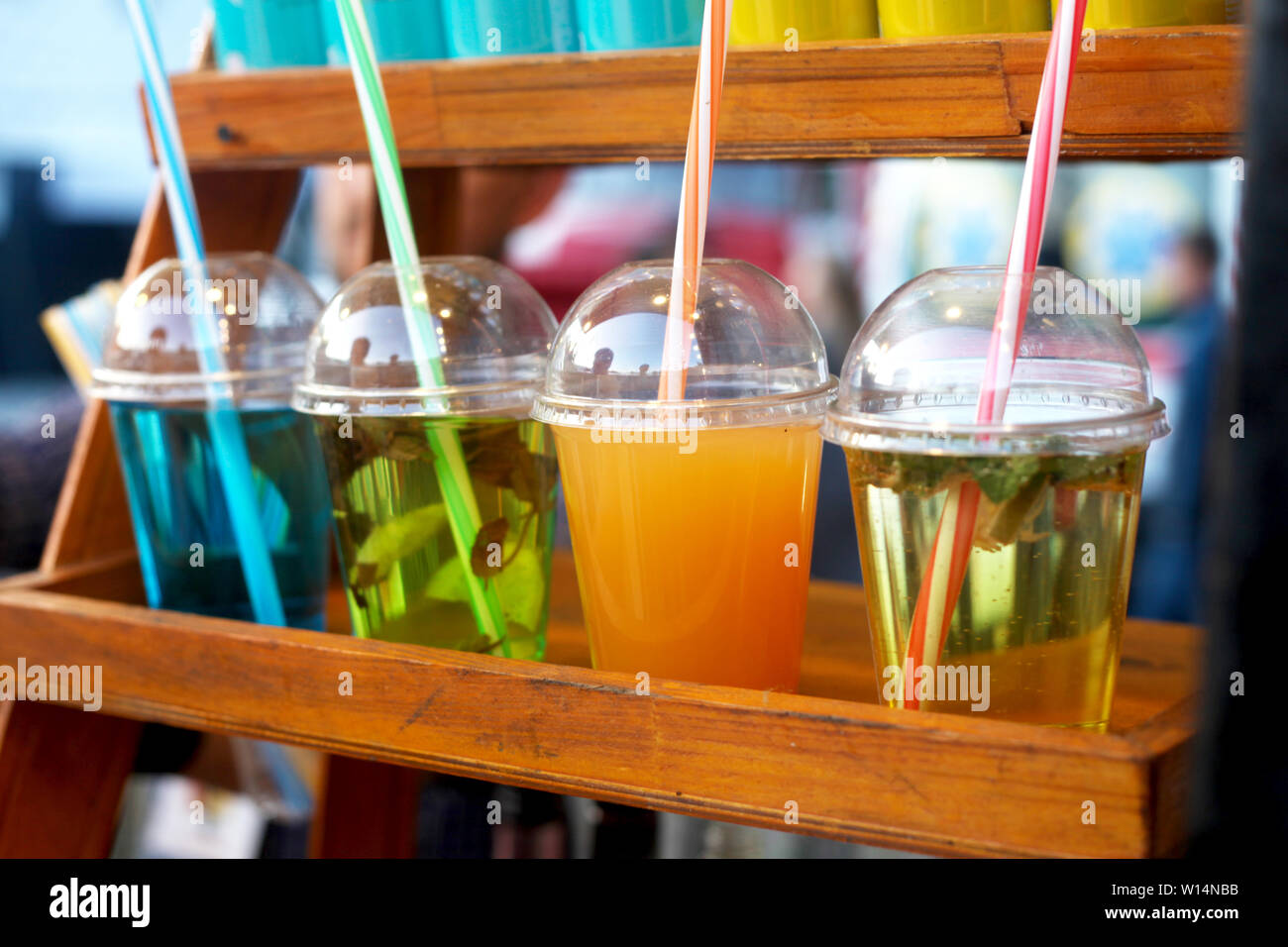 Colorful summer cold drinks in plastic cups on the display. Street food
