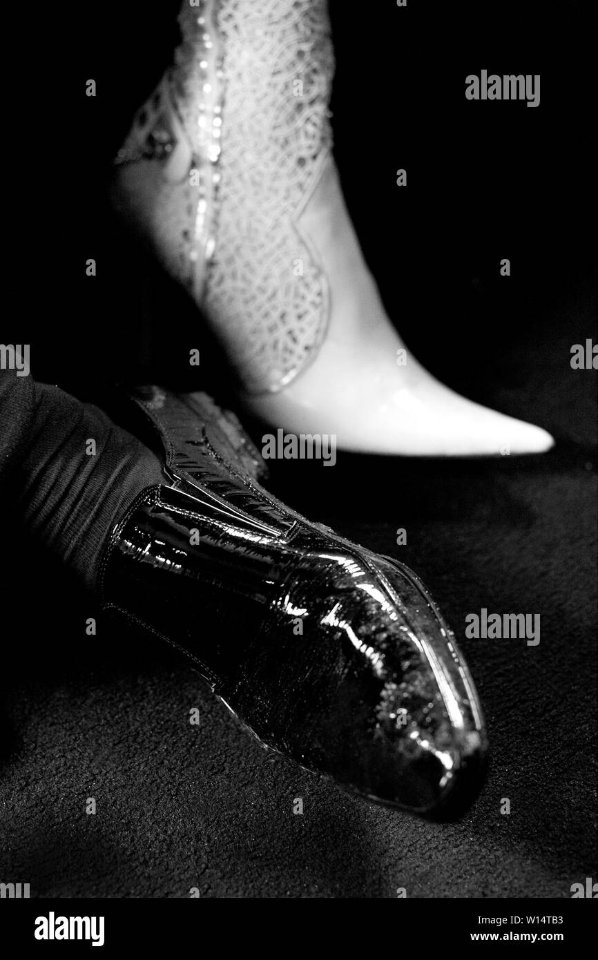 The legs of the bride and groom in a black shoe and white boot. Stock Photo