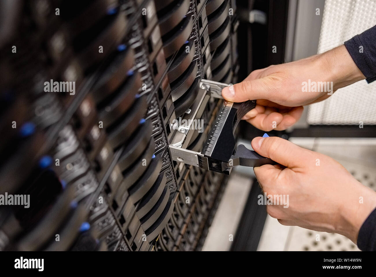 Male Technician Replacing Server Drive At Datacenter Stock Photo