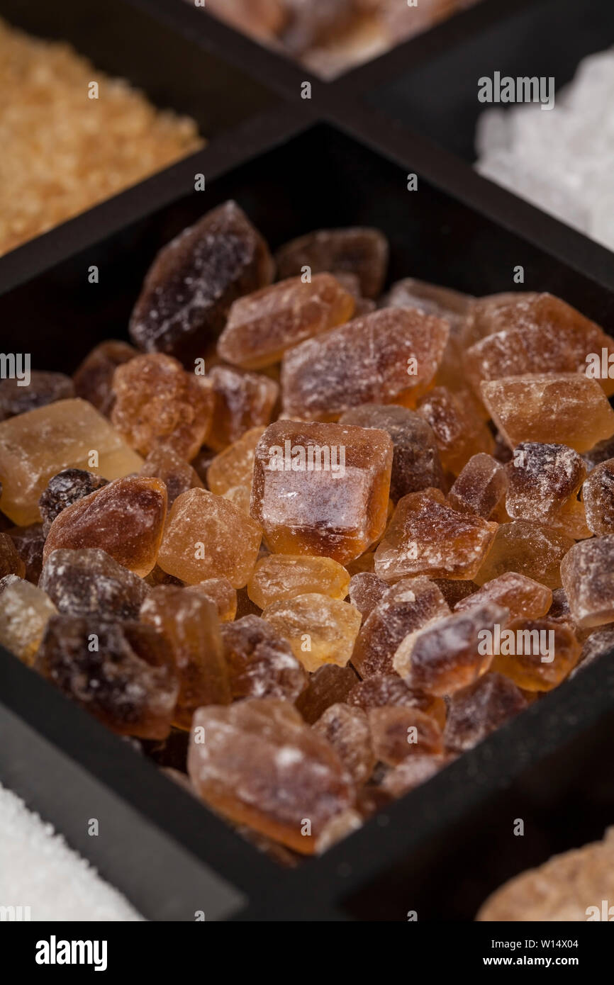 Various kinds of sugar in a wooden box. White refined, brown cane sugar collection Stock Photo