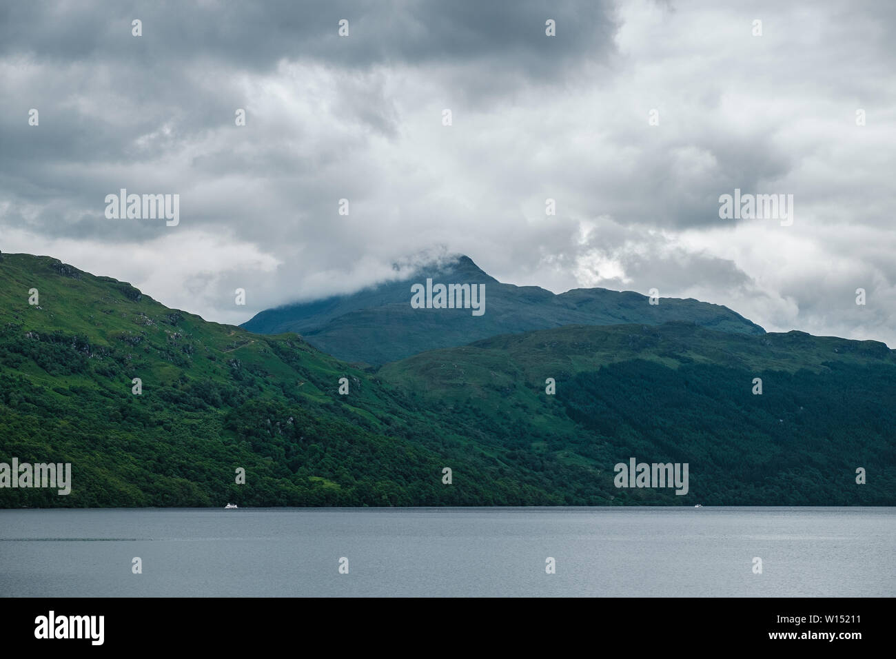 Scottish landscape with lake view and clouds covered green mountains. Summer 2019. Loch Lomond, Scotland Stock Photo