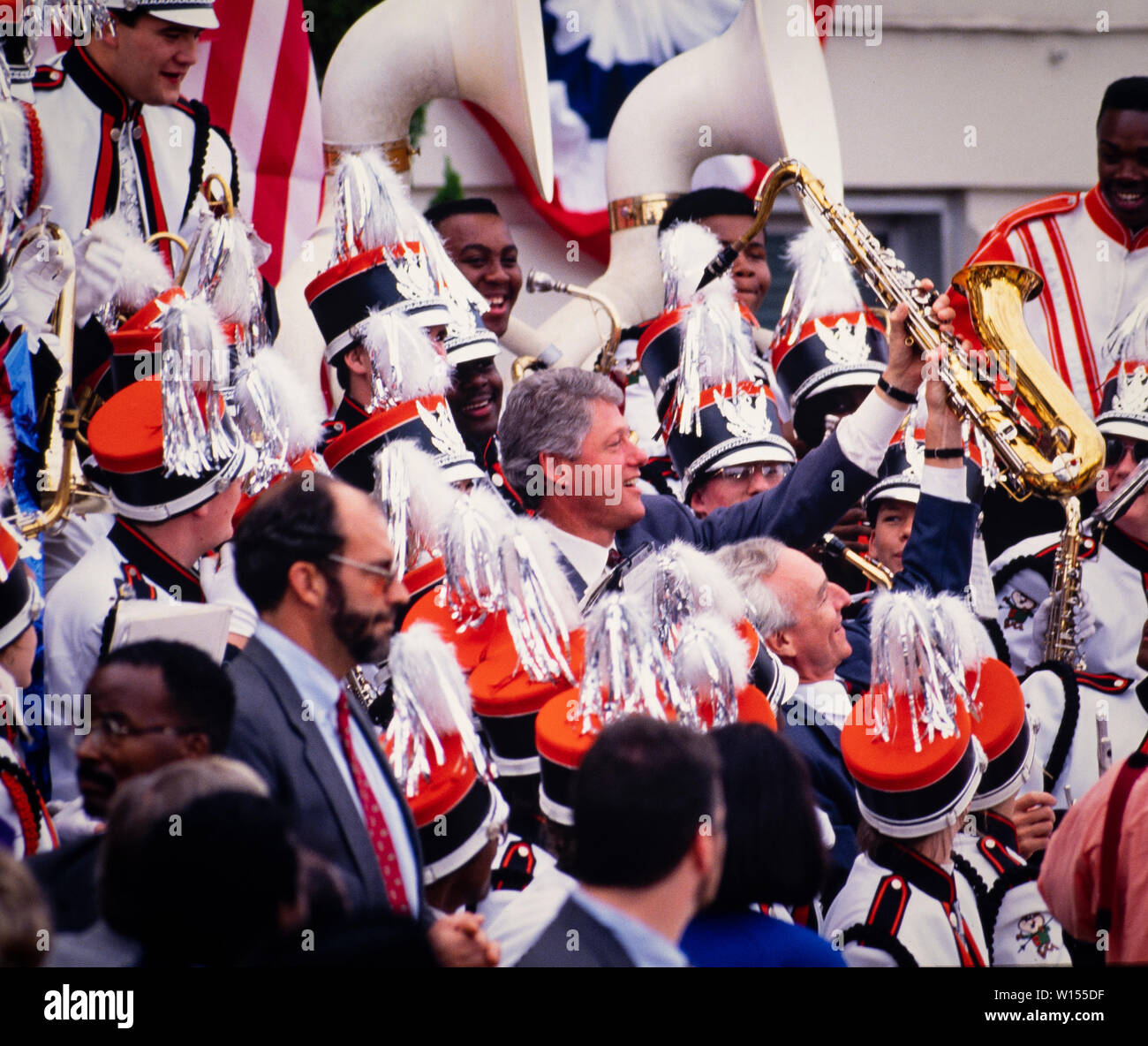 United States President Bill Clinton holds his saxophone aloft as he plays with a marching band in Macon, Georgia in 1993. Clinton is joined by US Senator Wyche Fowler of Georgia. Stock Photo