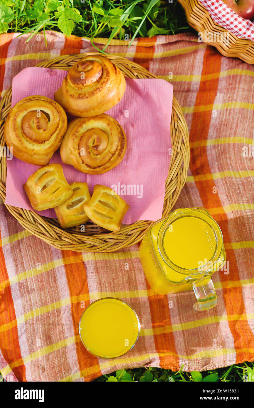 Picnic in nature. Picnic basket with fruit decanter juice and buns Stock Photo