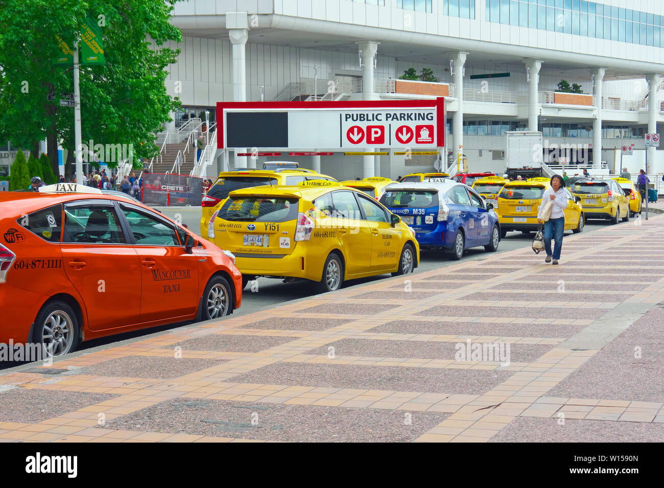 Small electric eCab taxis lined up outside Vancouver Convention Centre.  Vancouver, British Columbia, Canada Stock Photo