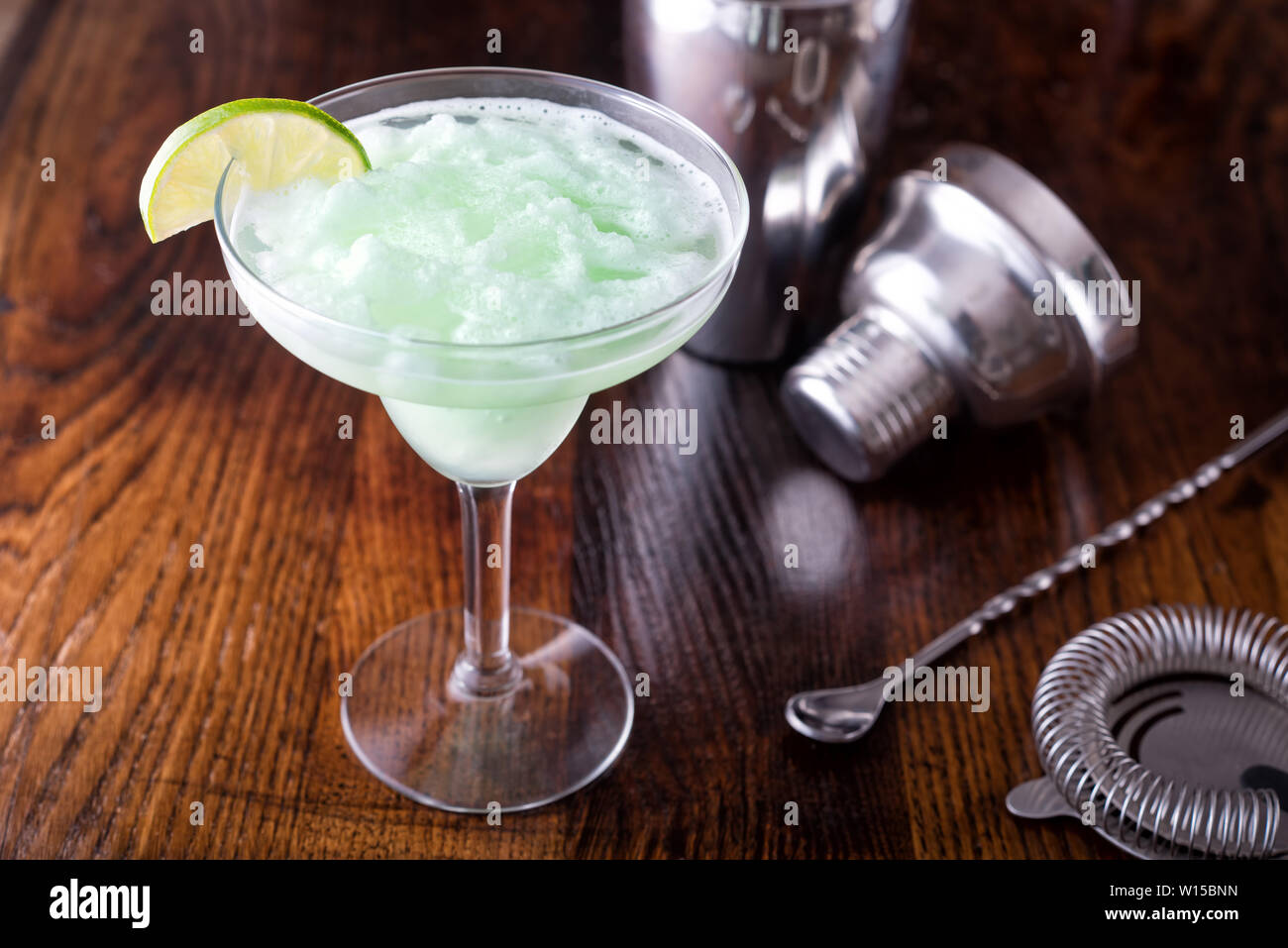 A delcious frozen lime daiquiri on a wooden bar counter top Stock Photo