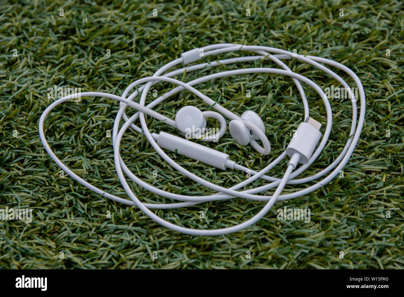 England, United Kingdom - June 30th 2019: The USB-C Google Pixel Buds of a Google Pixel 3 released by google an alphabet company in 2019. Image shows Stock Photo