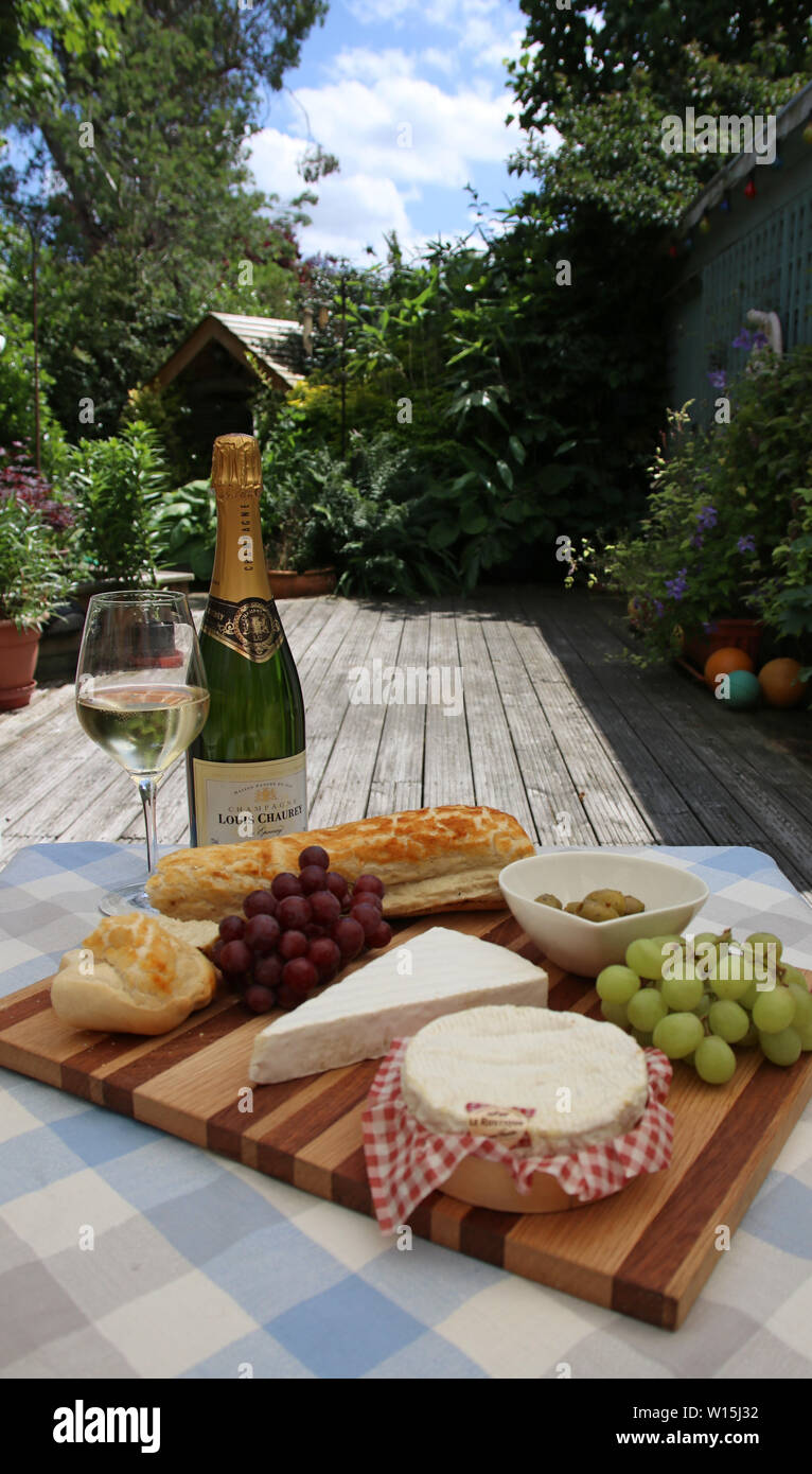 French lunch, in the garden, cheese and wine. Stock Photo