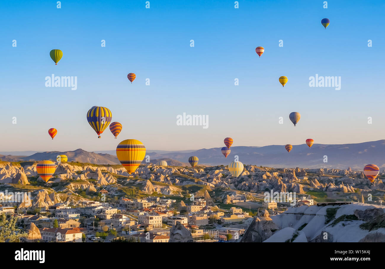 Colorful hot air balloons flying over rock landscape at Cappadocia ...