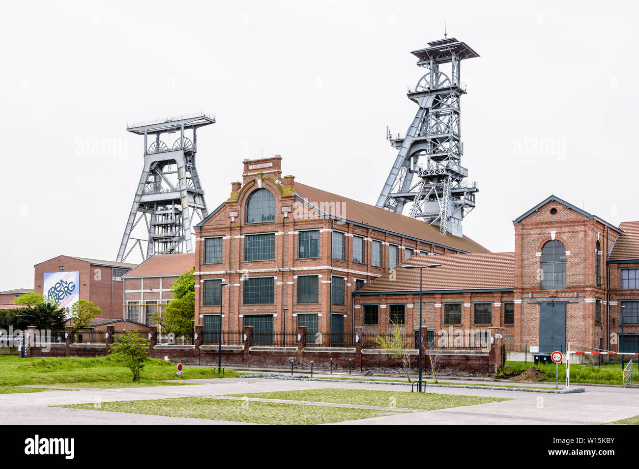 The former Arenberg mine site in Wallers in the mining basin of Nord-Pas de Calais, France, with shaft towers protruding above the brick buildings. Stock Photo