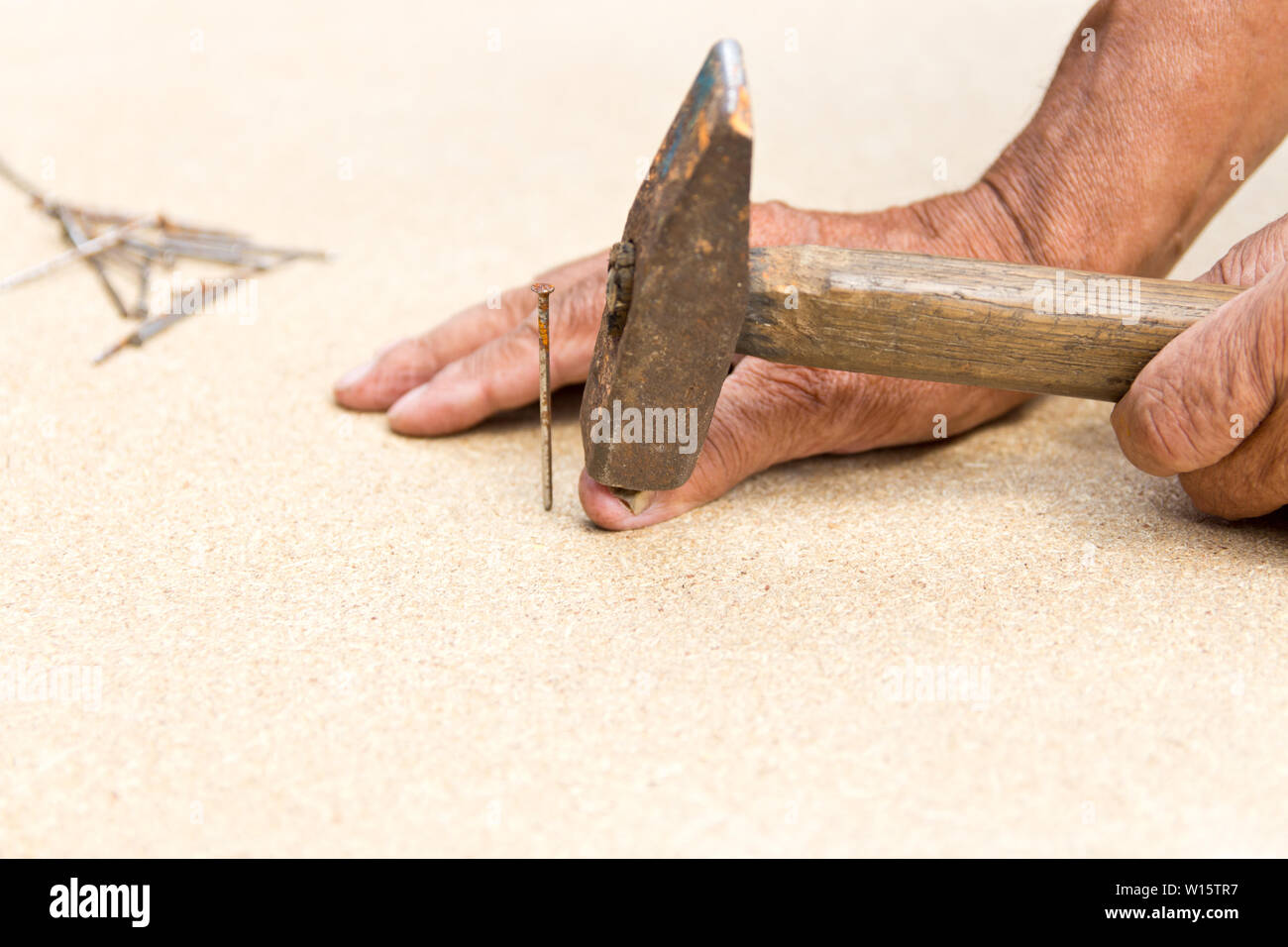 The man hit his finger with a hammer. Professional carpentry, woodwork