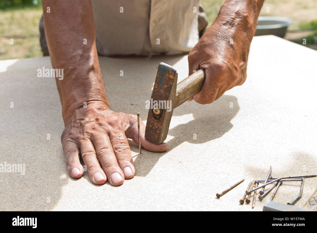 The man hit his finger with a hammer. Professional carpentry, woodwork
