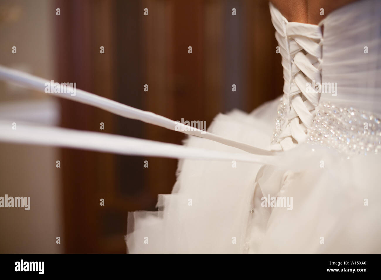 Bride from the back. Lacing the wedding dress Stock Photo Alamy