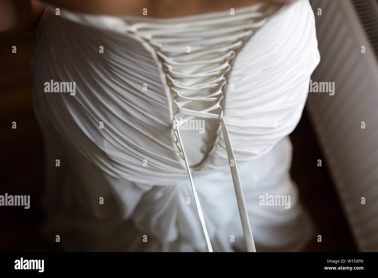 Bride from the back. Lacing the wedding dress Stock Photo Alamy