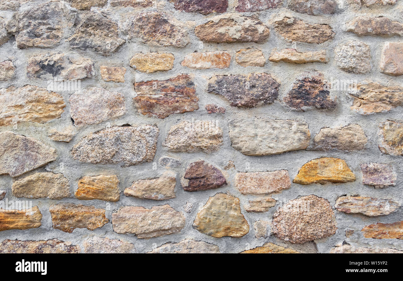 Old wall of big stones and cement, texture background. Stock Photo