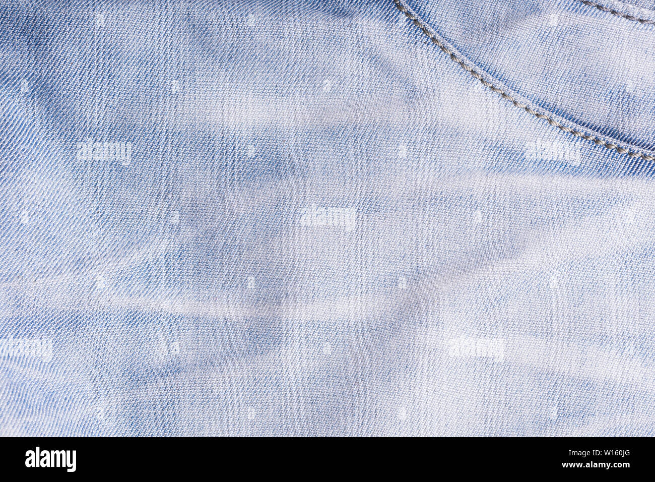 Blue denim. Cotton fabric, jeans. Creative vintage background. Pocket and zipper. The line is of poor quality. Cheap item Stock Photo
