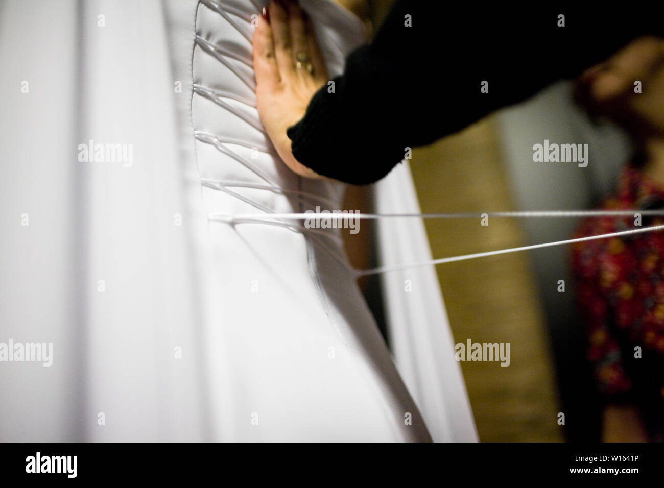 Bride from the back. Lacing the wedding dress Stock Photo Alamy