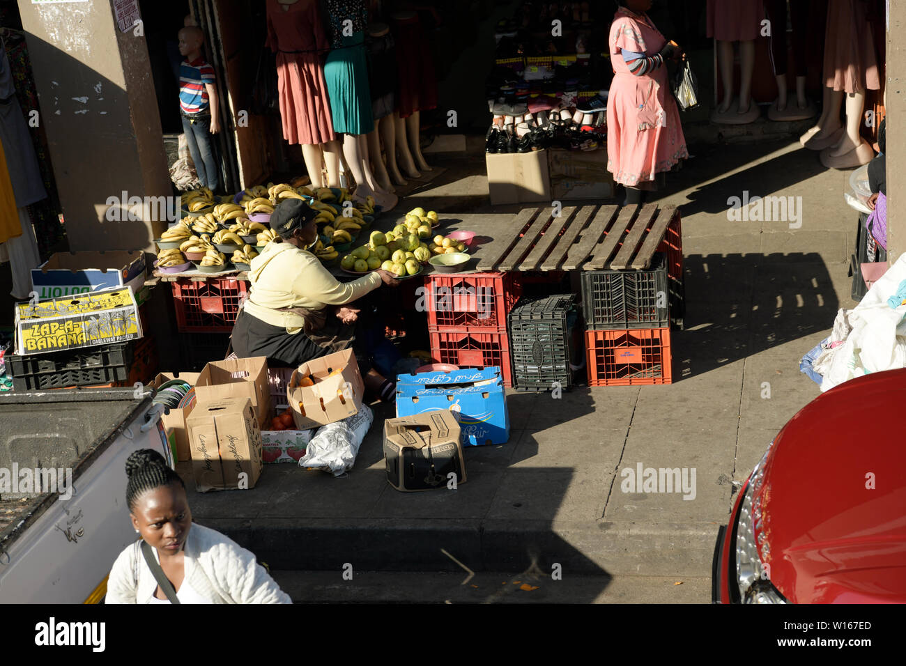 Durban, South Africa, adult female street vendor preparing for daily business on sidewalk, candid, photography, people, city, everyday, lifestyle Stock Photo