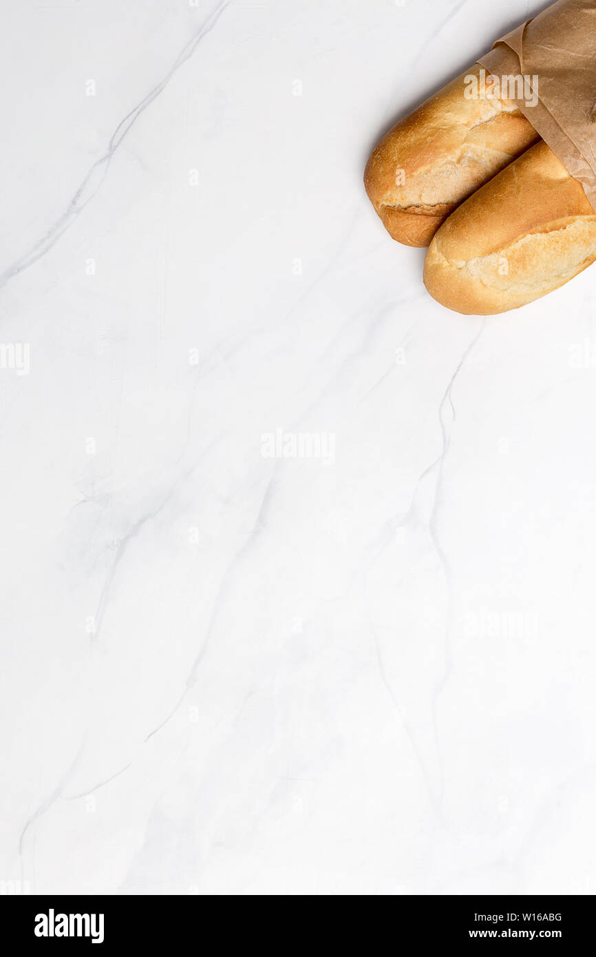 Bread on banner with white marble background. Flat lay, top view, vertical. Copy space for text Stock Photo