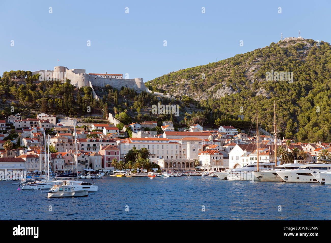 Hvar Town and its harbor as seen from a sea approach.  This Adriatic playground attracts celebrities and mega-yachts. Stock Photo