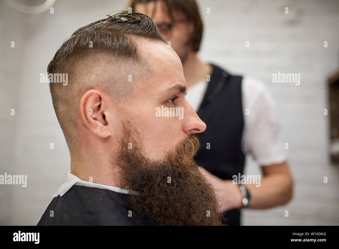 Brutal Guy In Modern Barber Shop Hairdresser Makes Hairstyle A