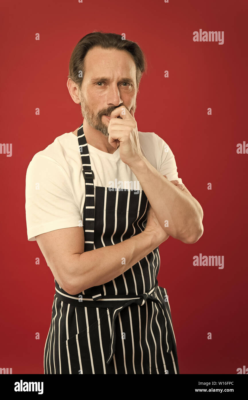 Concentrated On The Task Doing Household Bearded Mature Man In Striped Apron Senior Cook 