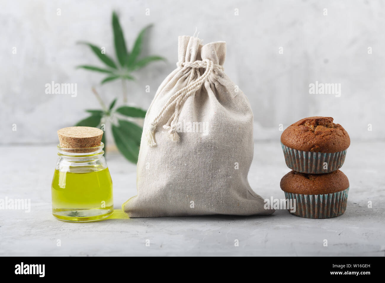 Cannabis oil extract, muffins and fabric bag produced using this plant. Gray background Stock Photo