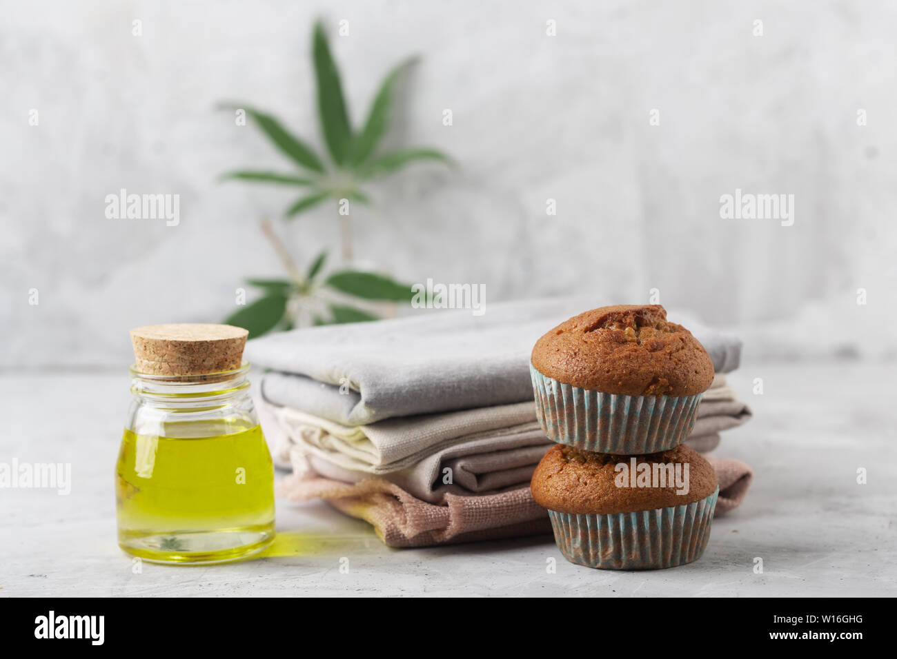 Different products from marijuana. Baking muffins from cannabis, natural CDB fabric and oil. Gray background Stock Photo