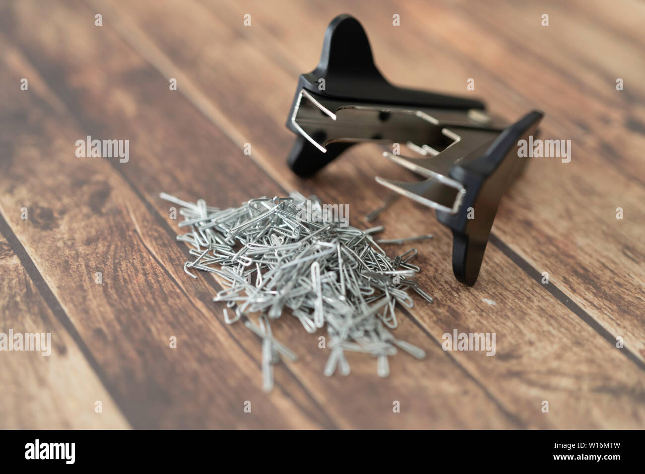 Staple pin remover with pile of staple pins Stock Photo Alamy