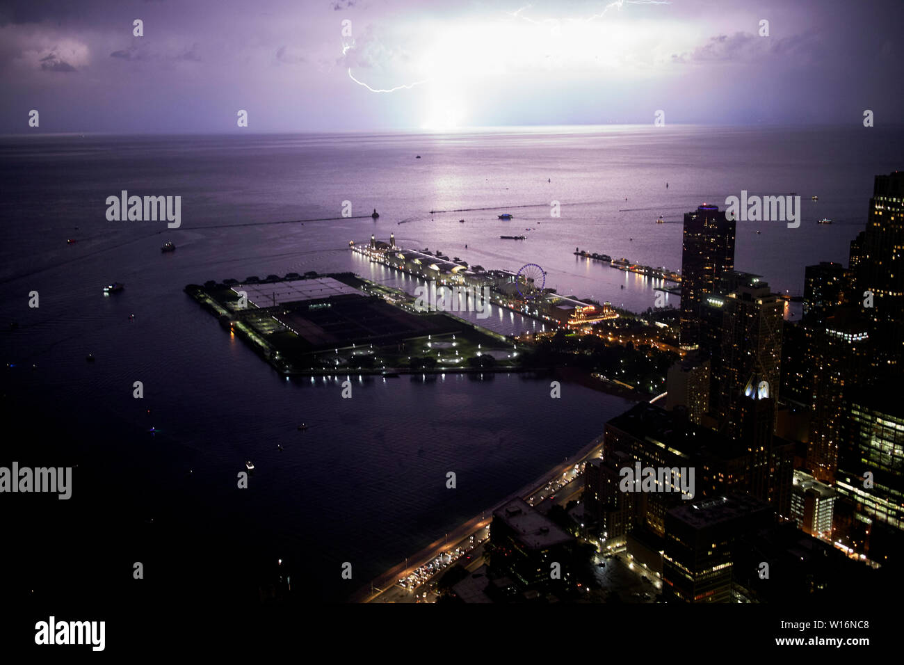 view from the 360 chicago observation deck the john hancock building as lighting strikes lake michigan at night over navy pier Chicago IL USA Stock Photo