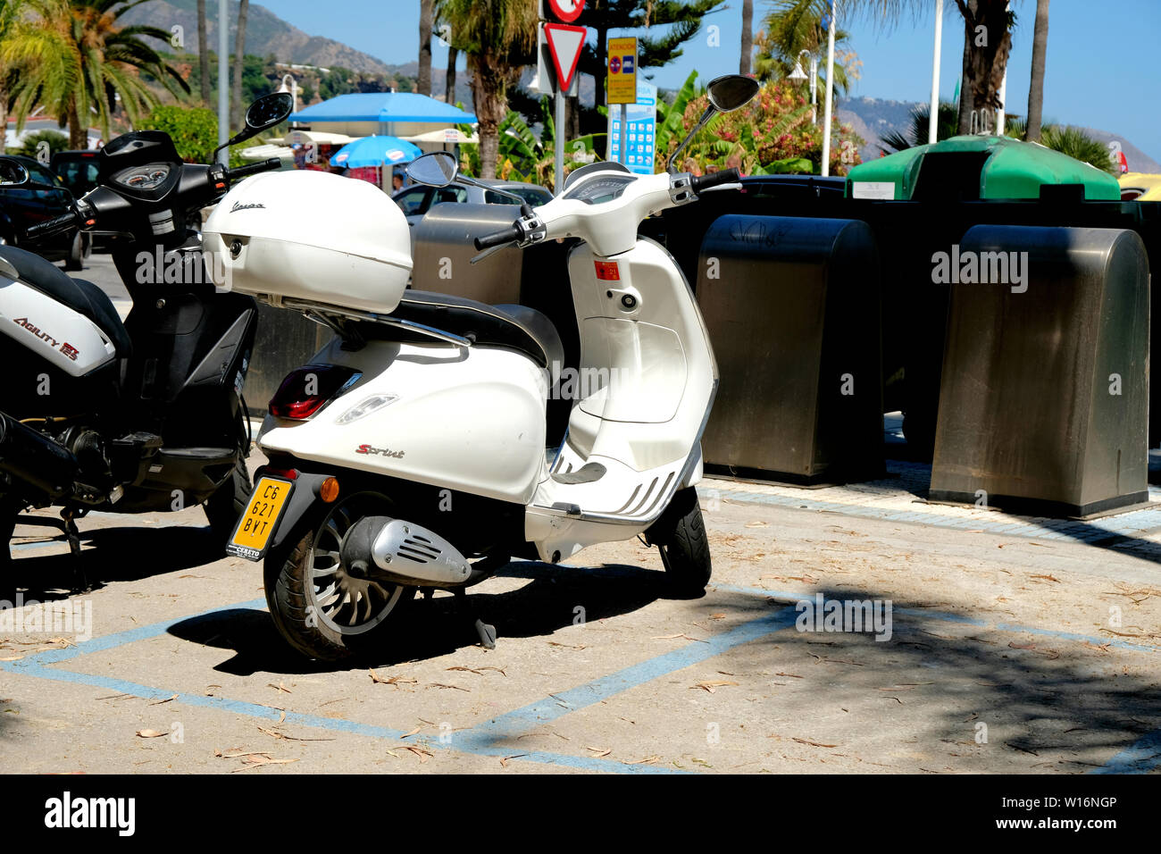 White Vespa Sprint with matching storage top box or top case parked near  some recycling bins or containers in Nerja, Spain Stock Photo - Alamy
