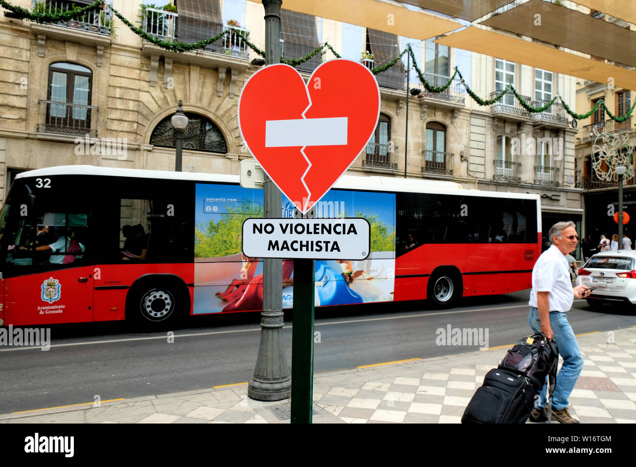 Sign in the shape of a broken heart pleading for the end to gender violence in downtown Granada, Spain; 'no violencia machista' (no macho violence). Stock Photo